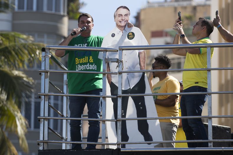 El senador brasileño Flavio Bolsonaro habla en la playa de Copacabana, en Río de Janeiro, el domingo 3 de agosto de 2025, mientras abraza una silueta de su padre, el expresidente Jair Bolsonaro, durante una manifestación para protestar contra un juicio en el que Jair Bolsonaro enfrenta cargos por su presunta participación en un intento de golpe de Estado en 2022. (AP Foto/Bruna Prado)