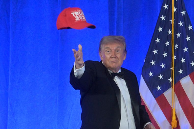 El presidente Donald Trump lanza una gorra con la inscripción Trump 2028 durante la cena de la Asociación de Corresponsales de la Casa Blanca en el hotel Waldorf Astoria, el viernes 24 de julio de 2026, en Washington. (AP Foto/Rod Lamkey, Jr.)