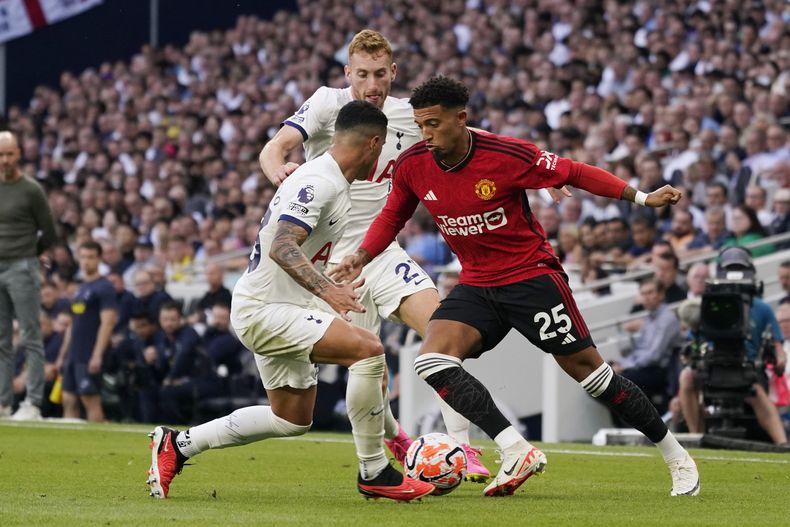 Jadon Sancho del Manchester United (derecha), y Pedro Porro del Tottenham disputan el balón durante un partido de la Liga Inglesa en el Tottenham Hotspur Stadium, en Londres, Inglaterra. Sábado 19 de agosto de 2023. (AP Foto/Alberto Pezzali)