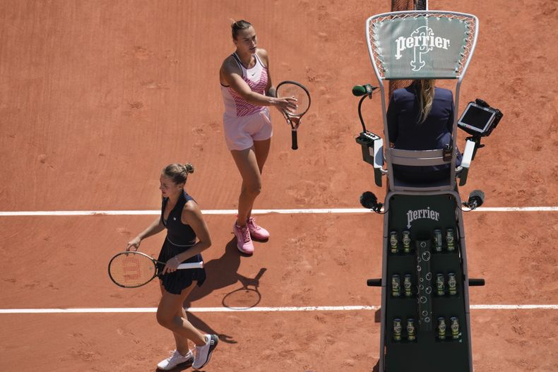 Aryna Sabalenka (arriba) y Marta Kostyuk no se saluda al final del partido de la primera ronda del Abierto de Francia, el domingo 28 de mayo de 2023. (AP Foto/Christophe Ena)