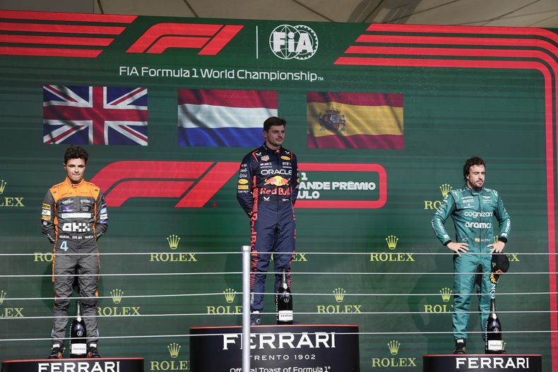 El piloto de Red Bull Max Verstappen en lo alto del podio junto a Landor Norris de McLaren y Fernando Alonso de Aston Martin tras el Gran Premio de Brasil en Interlagos el domingo 5 de octubre del 2023. (AP Foto/Andre Penner)