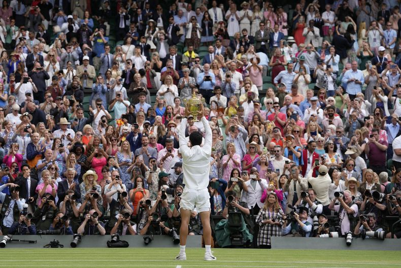 Carlos Alcaraz alza el trofeo de campeón tras derrotar a Novak Djokovic en la final masculina de Wimbledon, el domingo 16 de julio de 2023, en Londres. (AP Foto/Kirsty Wigglesworth)