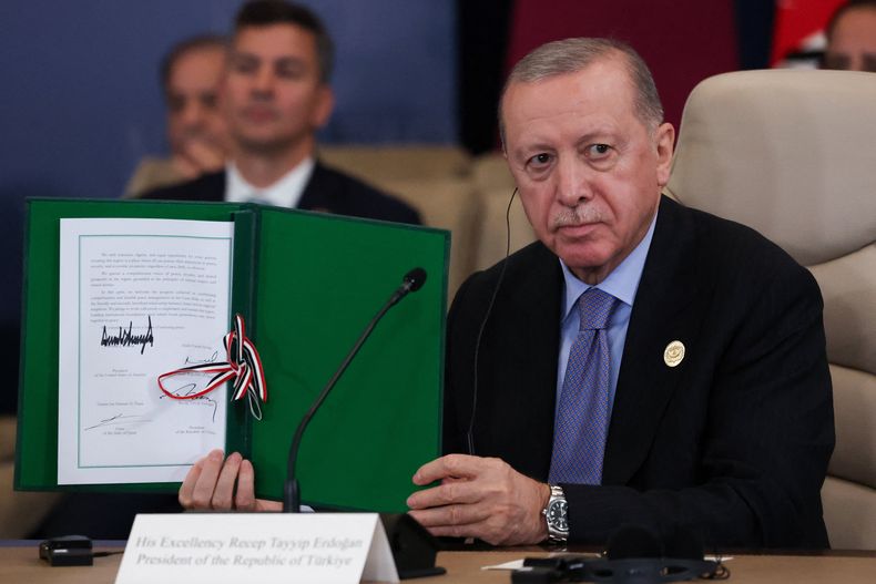 El presidente turco Recep Tayyip Erdogan sujeta un documento firmado en una cumbre en apoyo de un cese al fuego en la guerra entre Israel y Hamás, en Sharm El Sheij, Egipto, el 13 de octubre del 2025. (Suzanne Plunkett/Pool via AP)
