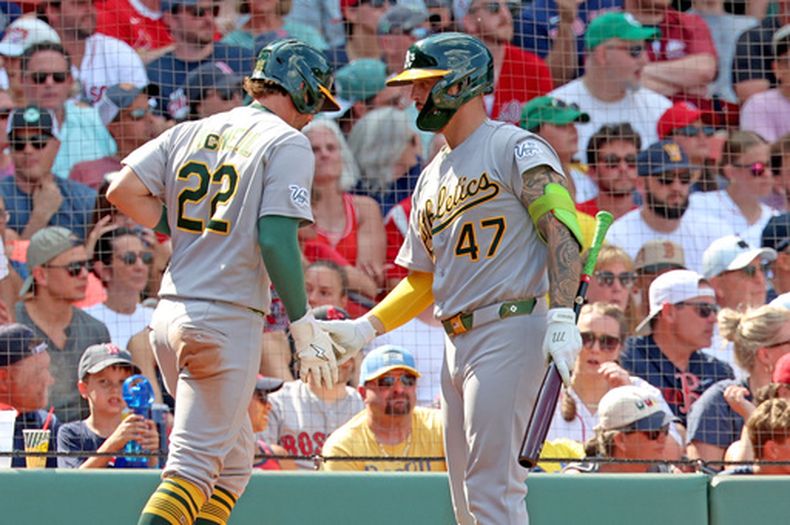 Jeff McNeil (22), de los Atléticos, saluda a su compañero Tommy White (47) tras anotar durante la octava entrada de un partido de béisbol contra los Medias Rojas de Boston, el domingo 9 de agosto de 2026, en Boston. (Foto AP/Mark Stockwell)