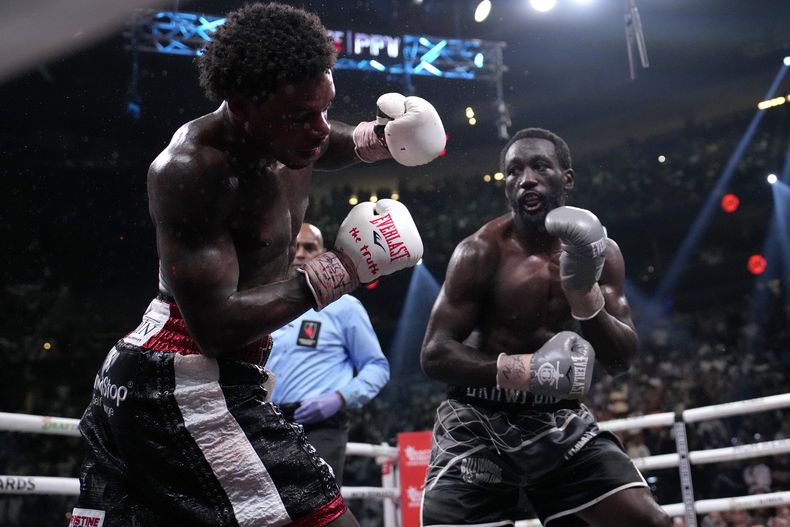 Terence Crawford (derecha) derriba a Erol Spence Jr. durante su pelea de unificación de los títulos welter, el sábado 29 de julio de 2023 en Las Vegas (AP Foto/John Locher)