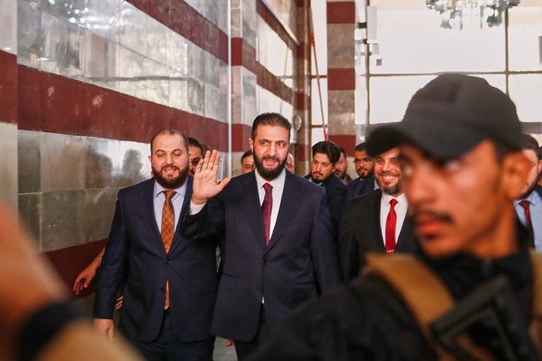 El presidente interino sirio Ahmad al Sharaa saluda al ingresar a un centro de votación, el 5 de octubre de 2025, en Damasco. (AP foto/Omar Sanadiki)