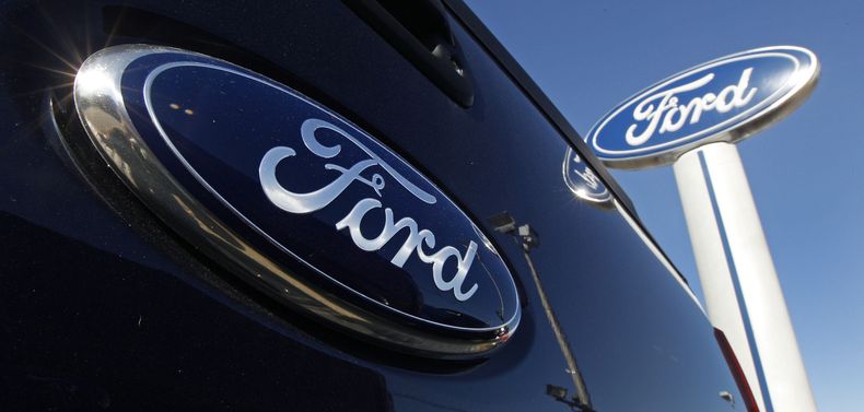 ARCHIVO – El logotipo de Ford en la puerta trasera de una camioneta y en un letrero de un concesionario de la marca en Salem, Nueva Hampshire. (AP Foto/Charles Krupa, Archivo)