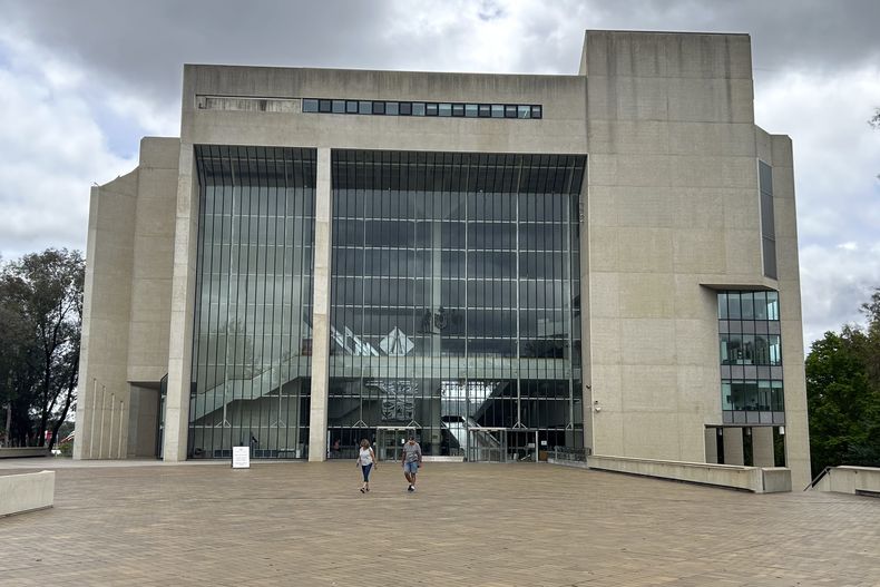 ARCHIVO - Gente camina fuera del edificio del Alto Tribunal en Canberra, Australia, el 23 de noviembre de 2023. (AP Foto/Rod McGuirk, Archivo)