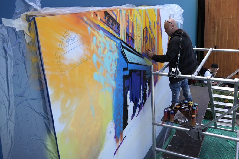 El artista callejero francés Marko93 rocía pintura sobre una obra de arte, durante los Juegos Olímpicos de Verano de 2024, el domingo 28 de julio de 2024, en París, Francia. (Foto AP/Yasin Dar)