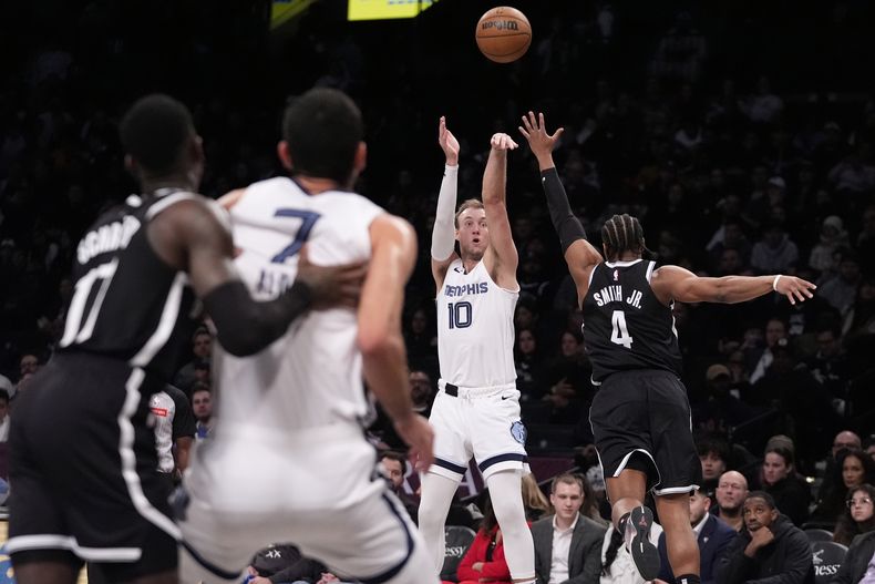 Luke Kennard (10), de los Grizzlies de Memphis, dispara de tres puntos sobre Dennis Smith Jr. (4), de los Nets de Brooklyn, durante la segunda mitad del juego de baloncesto de la NBA, el lunes 4 de marzo de 2024, en Nueva York. (AP Foto/Frank Franklin II)