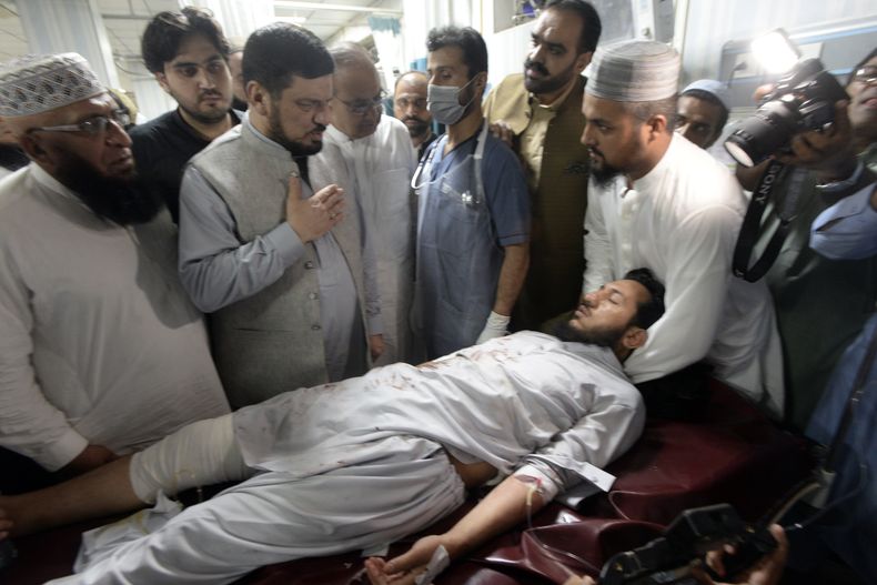 Varias personas transportan a una persona herida por una poderosa bomba a su llegada a un hospital el domingo 30 de julio de 2023, en Peshawar, Pakistán. La bomba estalló durante un mitin político. (AP Foto/Muhammad Sajjad)