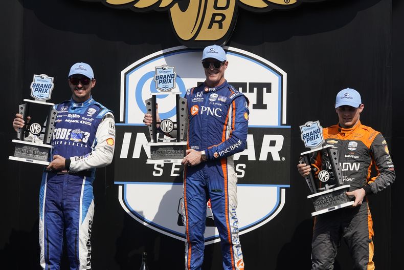 El neozelandés Scott Dixon (centro) , Graham Rahal (izquierda) y el mexicano Pato OWard sostienen sus trofeos en el podio del Gran Premio de Indianápolis,e l sábado 12 de agosto de 2023 (AP Foto/Darron Cummings)