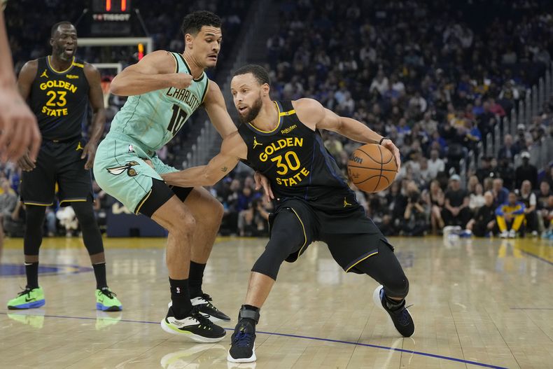 Stephen Curry, de los Warriors de Golden State, avanca hacia la cesta frente a Josh Green, de los Hornets de Charlotte, el martes 25 de febrero de 2025 (AP Foto/Jeff Chiu)