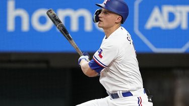 Cory Seager, de los Rangers de Texas, sigue el movimiento después de batear un sencillo productor de una carrera en la segunda entrada del juego de béisbol en contra de los Medias Blancas de Chicago, el miércoles 2 de agosto de 2023, en Arlington, Texas. Sam Huff anotó en la jugada. (AP Foto/Tony Gutierrez)
