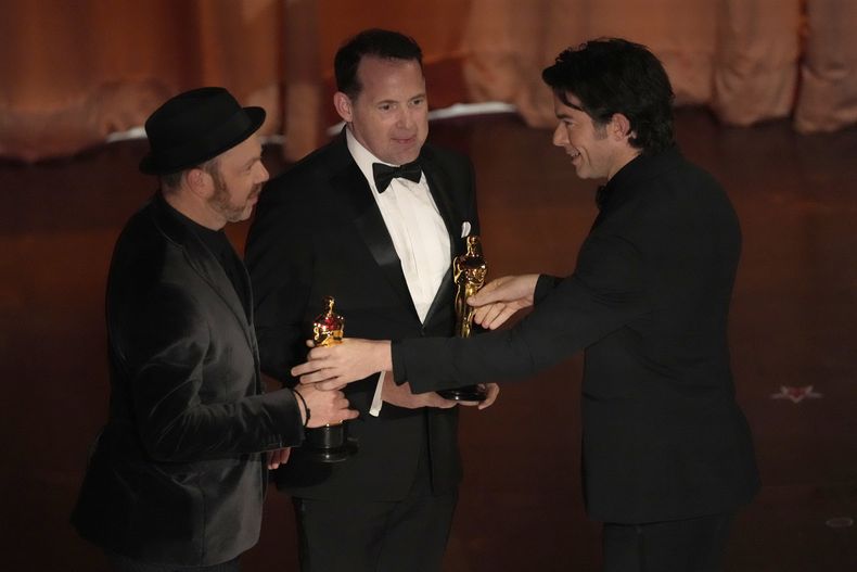 John Mulaney, derecha, entrega el premio a mejor sonido a Tarn Willers, izquierda, y Johnnie Burn por The Zone of Interest en los Oscar el domingo 10 de marzo de 2024, en el Teatro Dolby en Los Ángeles. (Foto AP/Chris Pizzello)
