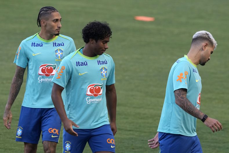 Los brasileños Bruno Guimaraes (derecha), Endrick (centro) y Raphinha se entrenan previo al partido de las eliminatorias del Mundial contra Perú, el domingo 13 de octubre de 2024, en Brasilia, (AP Foto/Eraldo Peres)