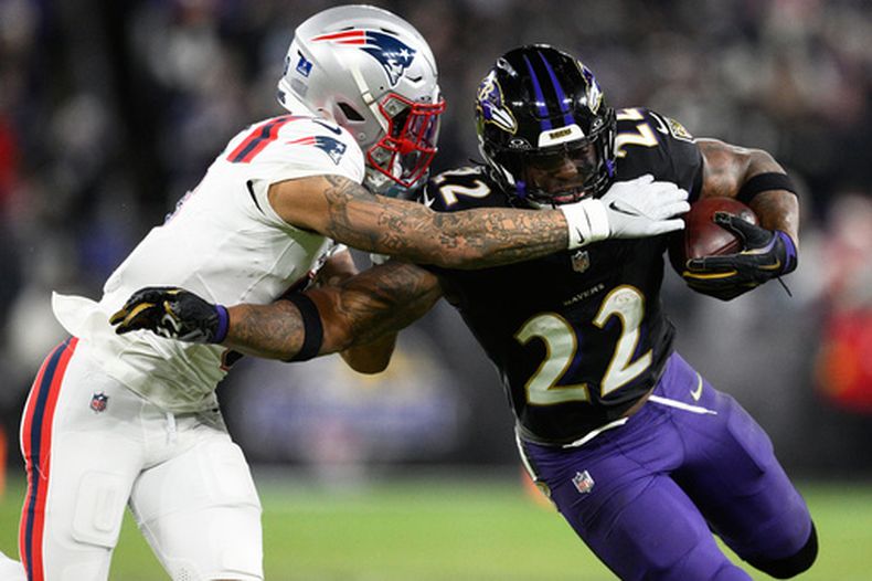 ARCHIVO - Foto del 21 de diciembre del 2025, el corredor de los Ravens de Baltimore Derrick Henry corre con el balón frente al cornerback de los Patriots de Nueva Inglaterra Christian Gonzalez. (AP Foto/Nick Wass, Archivo)