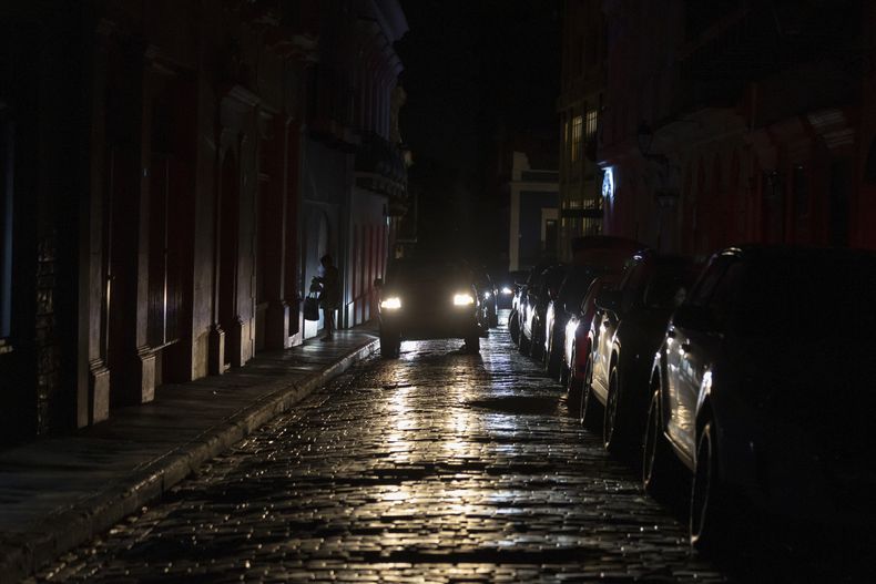 Los faros de un auto iluminan el piso de las calles del Viejo San Juan durante un apagón el miércoles 16 de abril de 2025, en Puerto Rico. (AP Foto/Alejandro Granadillo)