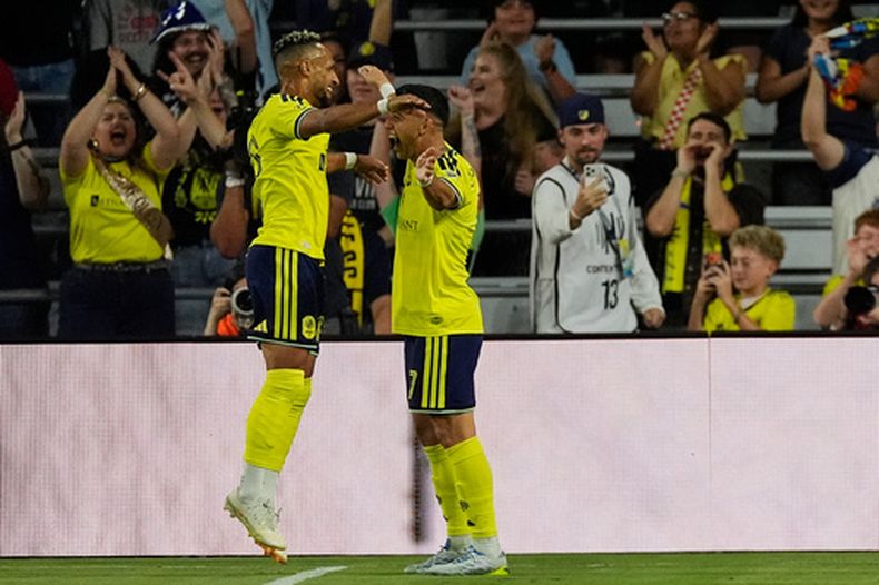 El delantero de Nashville Hany Mukhtar celebra con su compañero Cristian Espinoza tras anotar ante Toronto FC el sábado 26 de septiembre del 2026. (AP Foto/George Walker IV)