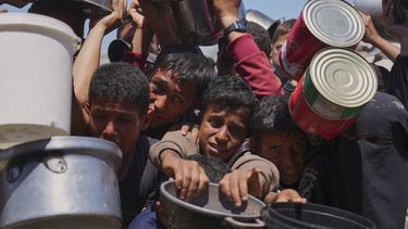Palestinos tratan de obtener alimentos donados en una cocina comunitaria en Jan Yunis, en el sur de la Franja de Gaza, el lunes 2 de junio de 2025. (AP Foto/Abdel Kareem Hana)
