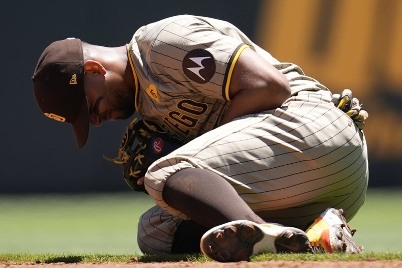 El segunda base de los Padres de San Diego, Xander Bogaerts (2), se arrodilla después de una lesión al fildear una pelota bateada por Ronald Acuña Jr., de los Bravos de Atlanta, en la tercera entrada de un juego de béisbol, el lunes 20 de mayo de 2024, en Atlanta. (AP Foto/Mike Stewart)