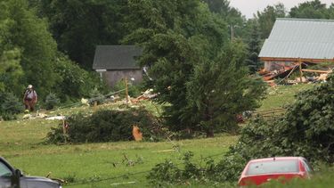 americateve | Un bombero camina entre escombros junto a la carretera Goff Road en Smithfield, Nueva York, tras una tormenta el martes, 8 de julio del 2014.(Foto AP/Oneida Daily Dispatch, John Haeger)