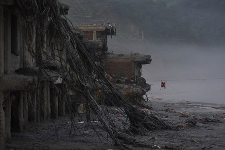 Unos residentes cruzan sobre el río Trishuli mediante una tirolesa recién instalada tras las repentinas inundaciones en Devighat, en el distrito de Nuwakot, Nepal, el lunes 7 de septiembre de 2026. (Foto AP/Niranjan Shrestha)