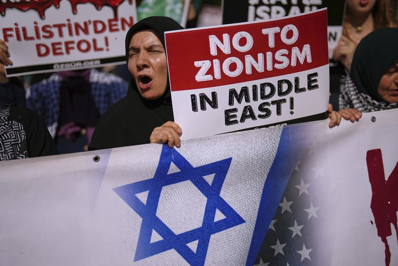 ARCHIVO - Gente corea lemas durante una protesta contra Israel en Estambul, Turquía, el sábado 21 de junio de 2025. Los carteles, de izquierda a derecha, dicen Fuera de Palestina, en turco, y No al sionismo en Oriente Medio en inglés. (AP Foto/Francisco Seco, Archivo)