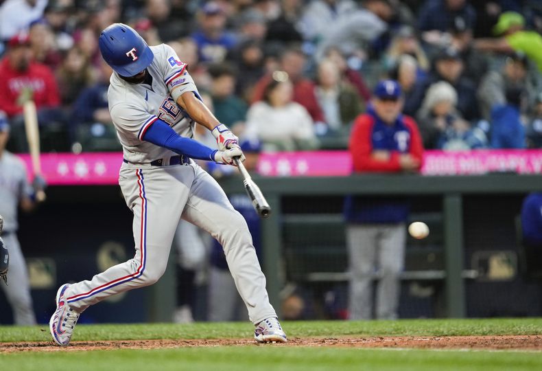 El jugador de los Rangers de Texas Marcus Semien pega un sencillo para romper un juego perfecto del pitcher abridor de los Marineros de Seattle Logan Gilbert en el séptimo inning de su juego de béisbol el lunes 8 de mayo de 2023 en Seattle. (AP Foto/Lindsey Wasson)