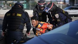 Un manifestante es arrestado por agentes de la Patrulla de Caminos de California cerca del edificio federal en el centro de Los Ángeles el martes 10 de junio de 2025. (AP Foto/Eric Thayer)