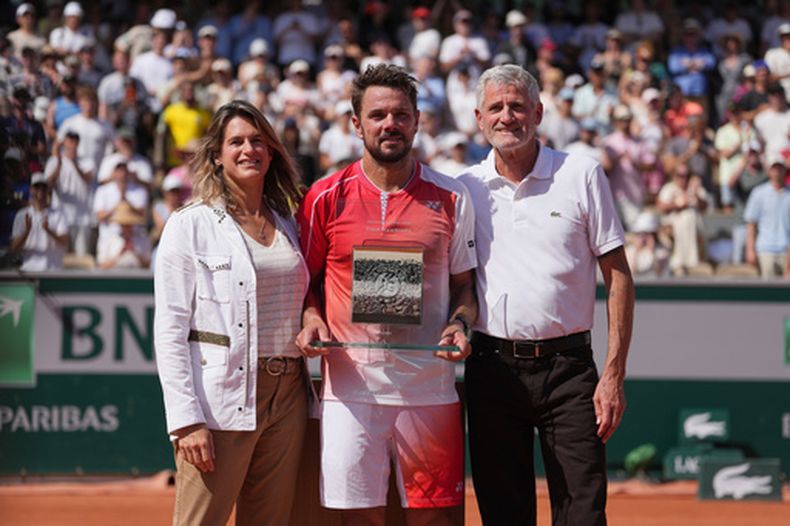 La directora de Roland Garros y extenista Amelie Mauresmo, junto al suizo Stan Wawrinka y el presidente de la Federación de Tenis de Francia Gilles Moretton posan al final del encuentro de primera ronda de Wawrinka ante el neerlandés Jesper De Jong el lunes 25 de mayo del 2026. (AP Foto/Thibault Camus)