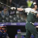 Ryan McMahon, de los Rockies de Colorado, observa la pelota al conectar un jonrón de dos carreras en el juego del sábado 27 de mayo de 2023 ante los Mets de Nueva York (AP Foto/David Zalubowski)