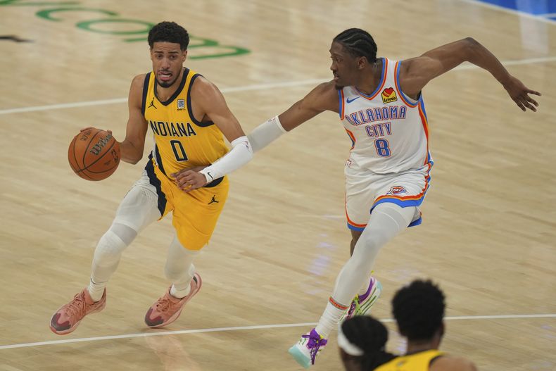 Tyrese Haliburton (0), de los Pacers de Indiana, lleva el balón hacia la canasta mientras Jalen Williams (8), del Thunder de Oklahoma City, defiende durante la primera mitad del quinto juego de las Finales de la NBA, el lunes 16 de junio de 2025, en Oklahoma City. (AP Foto/Nate Billings)