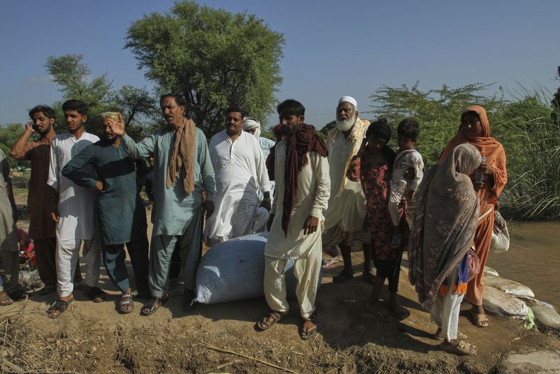 Aldeanos miran a un bote de rescate que llega para evacuarlos de una zona inundada en Muhammad Pur Ghotta, en el distrito de Multan, Pakistán, el jueves 11 de septiembre de 2025. (AP Foto/Asim Tanveer)