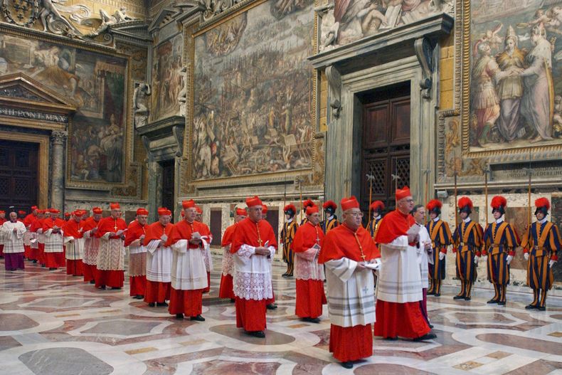 ARCHIVO - Los cardenales caminan en procesión hacia la Capilla Sixtina en el Vaticano, al comienzo del cónclave, el 18 de abril de 2005. (Osservatore Romano via AP, archivo)