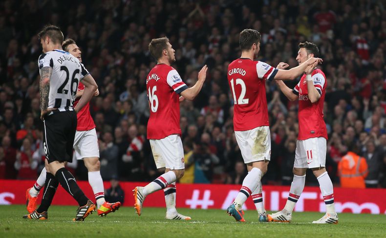 Mesut Ozil (derecha) celebra con sus compa&ntilde;eros del Arsenal luego de anotar frente al Newcastle, el lunes 28 de abril de 2014, en un encuentro de la Liga Premier inglesa (AP Foto/Alastair Grant)