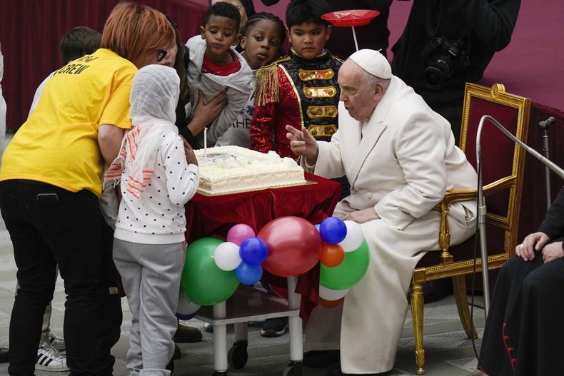 El papa Francisco sopla una vela sobre un pastel mientras celebra su cumpleaños con niños en el Aula Pablo VI del Vaticano, el domingo 17 de diciembre de 2023. Francisco cumplió 87 años. (Foto AP/Alessandra Tarantino)