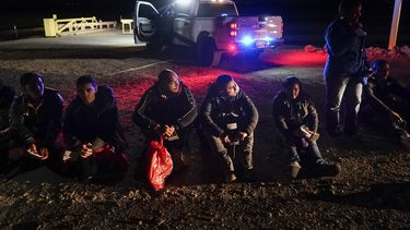 Migrantes esperan a ser procesados después de cruzar la frontera, el 6 de enero de 2023, cerca de Yuma, Arizona. (AP Foto/Gregory Bull, Archivo)