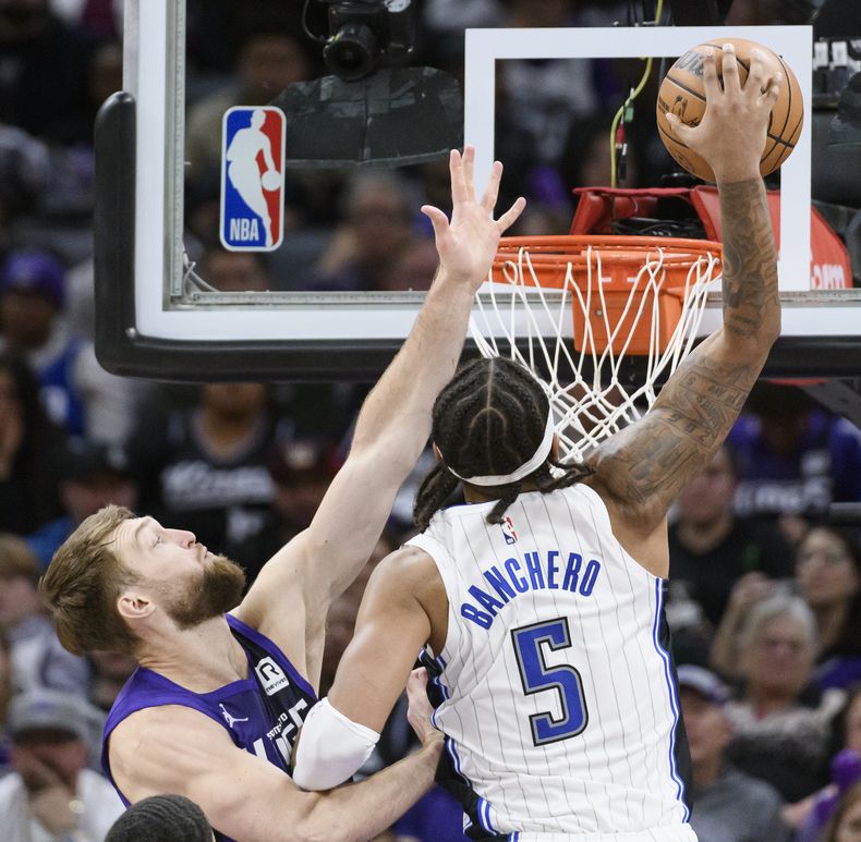 Paolo Banchero, del Magic de Orlando, realiza una volcada frente a Domantas Sabonis, de los Kings de Sacramento, el miércoles 5 de febrero de 2025 (AP Foto/Randall Benton)
