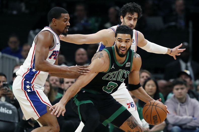 Jayson Tatum de los Celtics de Boston intenta mantener el balón alejado de DeAnthony Melton de los 76ers de Filadelfia en el encuentro del viernes 1 de diciembre del 2023. (AP Foto/Michael Dwyer)