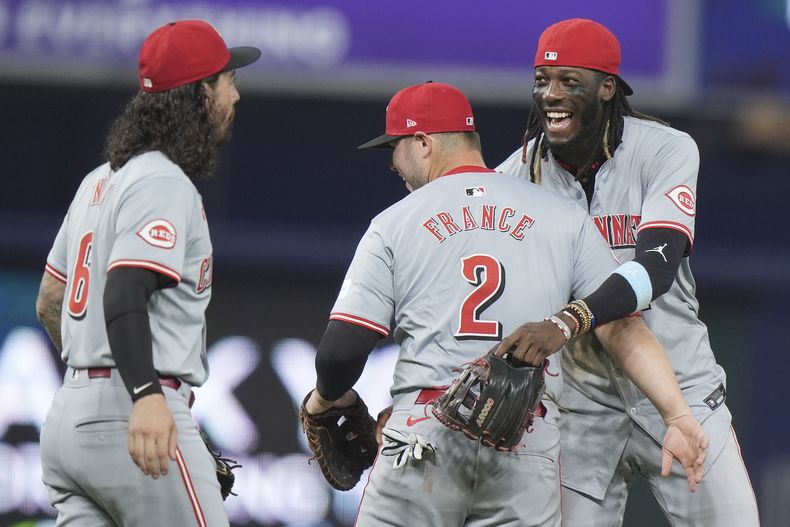 El campocorto de los Rojos de Cincinnati Elly De La Cruz celebra con el primera base Ty France y el segunda base Jonathan India la victoria ante los Marlins de Miami el martes 6 de agosto del 2024. (AP Foto/Wilfredo Lee)