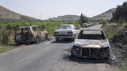 Vehículos calcinados, vistos a ambos lados de una carretera en la localidad cisjordana de al-Mughayyir, el 13 de abril de 2024. (AP Foto/Nasser Nasser)
