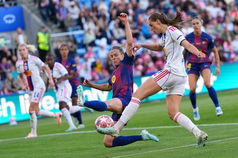 ARCHIVO - Foto del 23 de mayo del 2026, Jule Brand del Lyonnes intenta tirar superando a Irene Paredes del Barcelona en la final de la Liga de Campeones. (AP Foto/Kirsty Wigglesworth, Archivo)