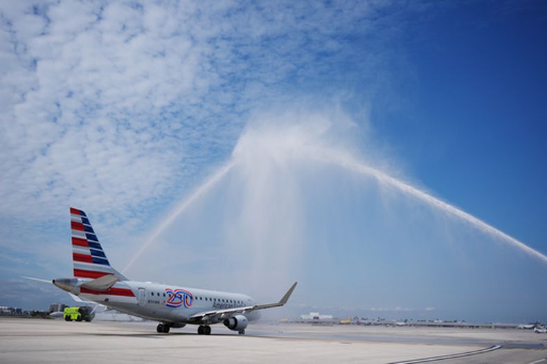 El vuelo AA3599 de American Airlines, el primer vuelo comercial directo entre Estados Unidos y Venezuela en siete años, recibe un saludo con cañones de agua mientras se aleja de la puerta de embarque, el jueves 30 de abril de 2026, en el Aeropuerto Internacional de Miami. (AP Foto/Rebecca Blackwell)