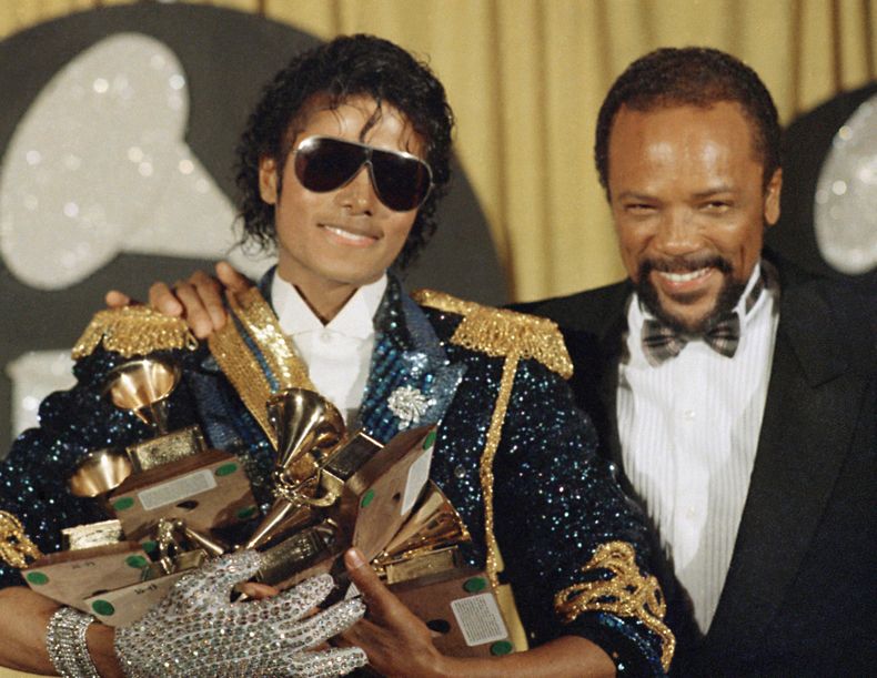 ARCHIVO - Michael Jackson, izquierda, sostiene ocho premios mientras posa con Quincy Jones en los premios Grammy en Los Ángeles, el 28 de febrero de 1984. Quincy Jones murió a los 91 años. (Foto AP/Doug Pizac, archivo)