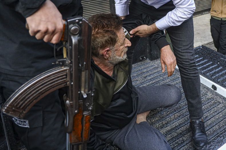 Un hombre identificado como Imad Mohammed Al-Mahmoud es detenido por las fuerzas de seguridad, el lunes 17 de febrero de 2025 en Tadamon, un suburbio de Damasco, Siria. (AP Foto/Omar Albam)
