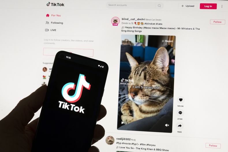 ARCHIVO - El logotipo de TikTok aparece en un teléfono móvil frente a un monitor de computadora que muestra la pantalla de inicio de TikTok el sábado 18 de marzo de 2023, en Boston. (AP Foto/Michael Dwyer, Archivo)
