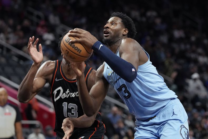 Jaren Jackson Jr. (13), de los Grizzlies de Memphis, es defendido por James Wiseman (13), de los Pistons de Detroit, durante la primera mitad del juego de baloncesto de la NBA, el lunes 1 de abril de 2024, en Detroit. (AP Foto/Carlos Osorio)