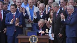 El presidente Donald Trump golpea un mazo que le entregó el presidente de la Cámara de Representantes, Mike Johnson (aplaudiendo en primer plano, a la izquierda), después de que promulgó su ley de recortes fiscales y al gasto público en la Casa Blanca, el viernes 4 de julio de 2025, en Washington. (AP Foto/Evan Vucci)