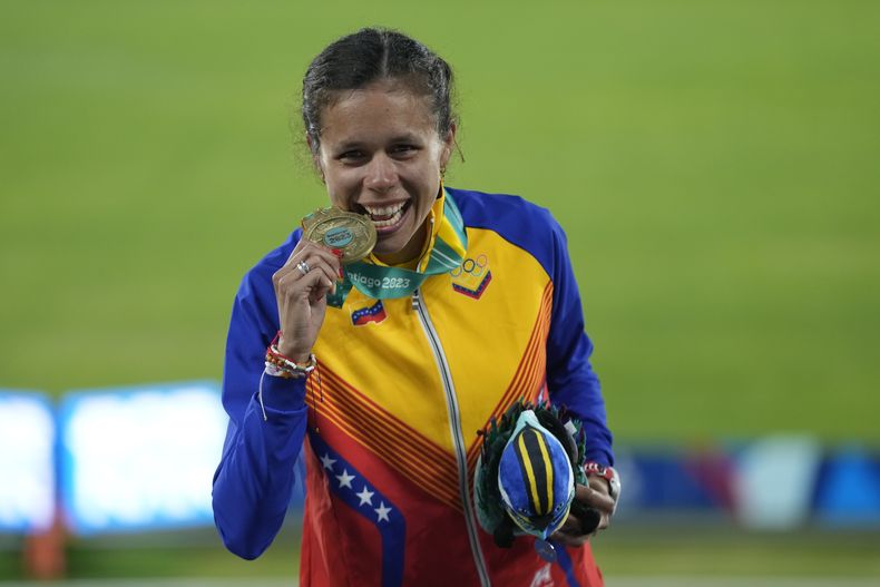 La venezolana Joselyn Brea celebra ganar la medalla de oro en el podio de los 5000 metros de los Juegos Panamericanos en Santiago, Chile, jueves, noviembre 2, 2023. (AP Foto/Esteban Felix)